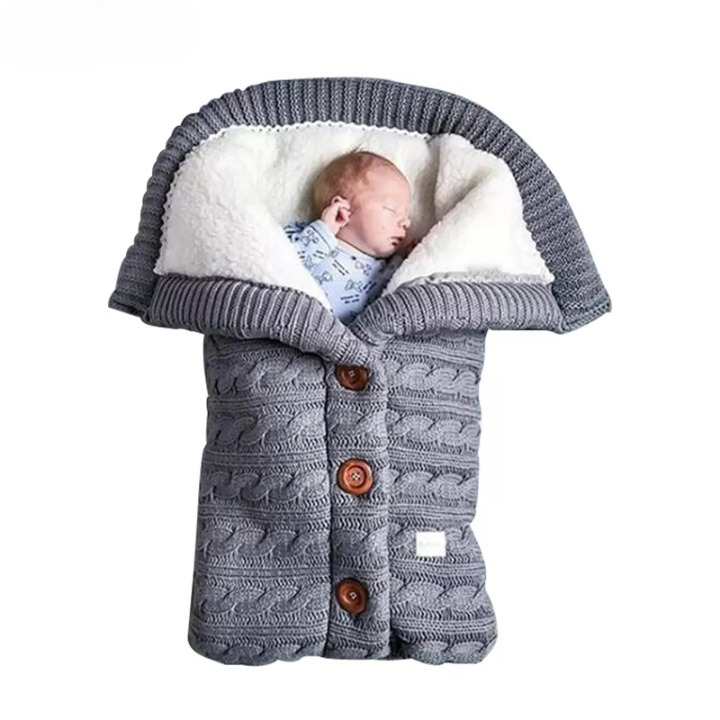 Sac de Couchage Hivernal pour Bébé en Cachemire avec Boutons sur un bébé sur fond blanc